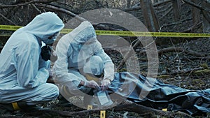 Detectives collecting evidence in a crime scene. Forensic specialists making expertise. Police officers and