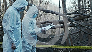 Detectives collecting evidence in a crime scene. Forensic specialists making expertise. Police officers and