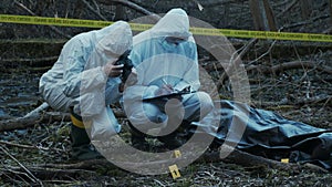 Detectives collecting evidence in a crime scene. Forensic specialists making expertise. Police officers and