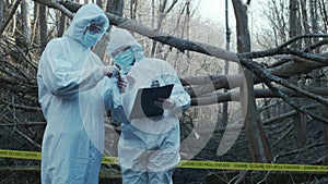 Detectives collecting evidence in a crime scene. Forensic specialists making expertise. Police officers and