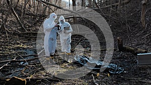 Detectives collecting evidence in a crime scene. Forensic specialists making expertise. Police officers and