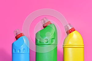 Detergent bottles on pink background. Detergents and laundry for cleaning. Household chemicals concept. Chemical liquid for