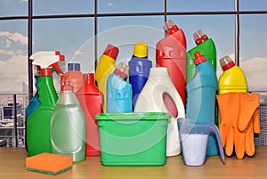 Detergent bottles and sponges on the window background. Detergents and laundry household chemicals for cleaning and washing.