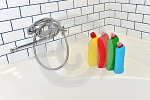 Detergent for clean in bathroom on background of white tiles. Detergents bottles and kitchen sponges. Household chemicals cleaning