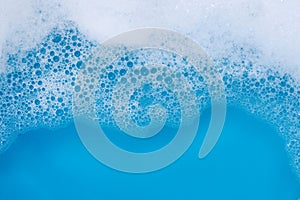 Detergent foam bubble on blue background. Top view