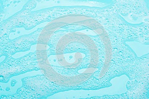 Detergent foam, shampoo, soap bubbles on blue background