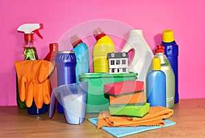 Detergent laundry bottles and sponge for washing on pink background. Household for cleaning and washing. Concentrated and anti-