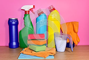 Detergent laundry bottles and sponge for washing on pink background. Household for cleaning and washing. Concentrated and anti-