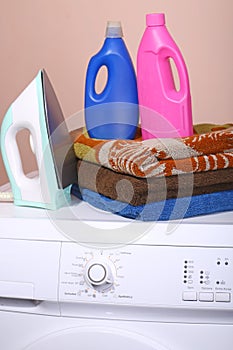 Detergent, towels and a washing machine with a key point in the life of a plain background