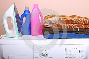 Detergent, towels and a washing machine with a key point in the life of a plain background