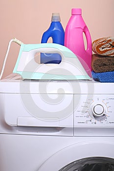 Detergent, towels and a washing machine with a key point in the life of a plain background