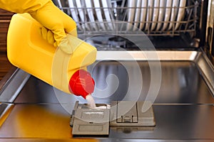 detergent for washing dishes in dishwashing machine, White washer powder pouring into a modern dishwasher