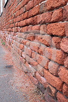 Deteriorating brick wall due to surface water from road traffic UK