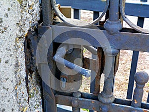 Deteriorating grunge wrought iron gate detail with lock
