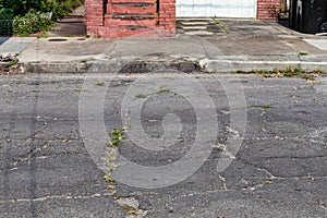 Deteriorating street surface, curb and sidewalk, crumbling infrastructure, transportation copy space