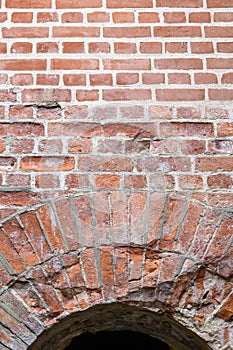 Deterioration in old brick masonry in arched doorway and wall