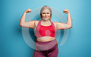 Determinated girl wants to remove fat and does gym at home. satisfied expression. cyan background