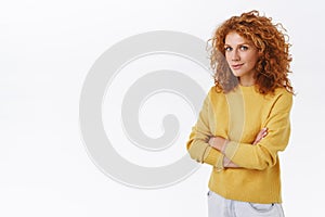 Determined, ambitious good-looking redhead curly woman in yellow sweater, feeling confident cross arms chest, standing