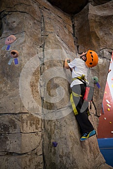 Determined boy practicing rock climbing