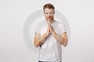 Determined, confident lucky good-looking sassy blond caucasian man, white t-shirt, press hands in pray, hope gesture