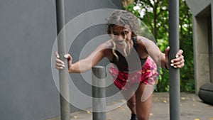 Determined female athlete performs intense sled push workout outdoors. Muscles flex as biethnic woman powers through