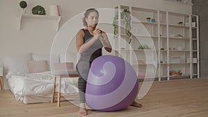 Determined female exercising with fitball at home