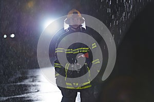 A determined female firefighter in a professional uniform striding through the dangerous, rainy night on a daring rescue