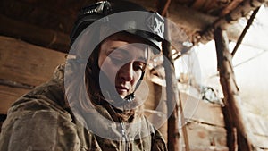 Determined Female Soldier in Protective Gear Inside Military Shelter