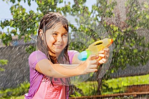 Determined girl in fun water gun fight game