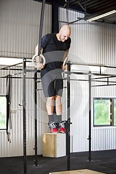 Determined Male Athlete Using Gymnastics Rings In Health Club