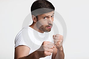 Determined Man Clenching Fists Ready To Fight Over White Background