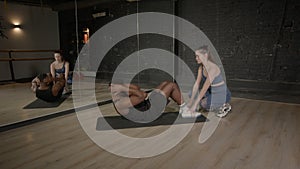 Determined muscular build African man doing sit-ups exercise with trainer