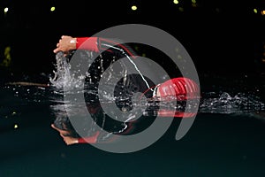 A determined professional triathlete undergoes rigorous night time training in cold waters, showcasing dedication and