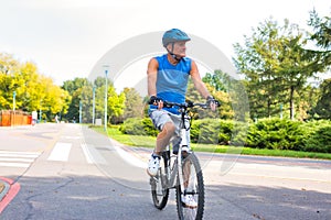 Determined senior man riding bicycle in park