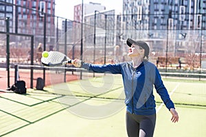 Determined sporty young woman playing padel in court