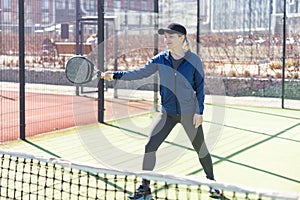 Determined sporty young woman playing padel in court