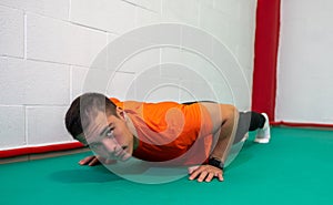 Determined strong young man doing push-ups