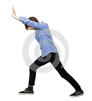 Determined teenage guy making effort as pushing an heavy invisible object isolated on white background. Confident boy, difficult