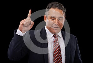 Determined to uphold his promises. A businessman on a black background pointing upwards.