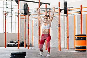 Determined weightlifter doing split jerk exercise