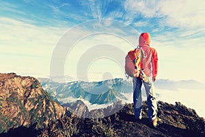 determined woman backpacker hiking on mountain peak