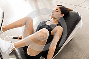 Determined Woman Doing Leg Press On Machine At Fitness Club