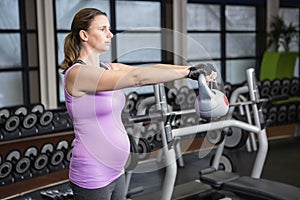 Determined woman lifting kettlebell