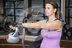 Determined woman lifting kettlebell