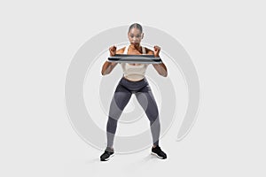 Determined Woman Performing Resistance Band Exercises in a Studio Setting