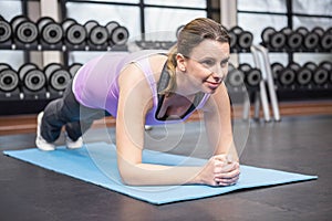 Determined woman planking on the mat