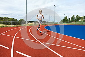 Determined Woman Running On Sports Tracks