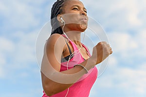 Determined young African woman working out jogging