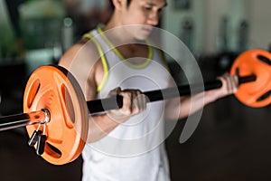 Determined young man holding a barbell while exercising bicep curls photo