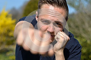 Determined young man punching at the camera